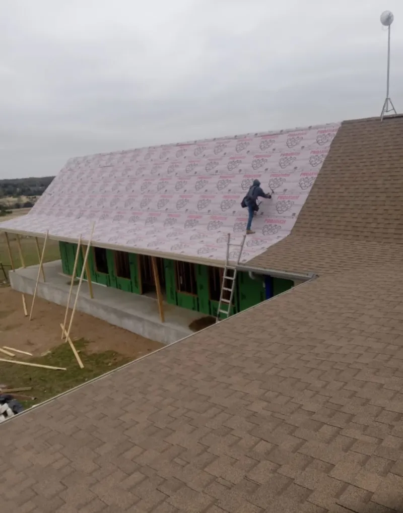 Worker preparing underlayment for a metal roof installation in Middletown